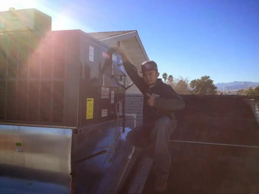 HVAC technician performing AC Tune-Up on a rooftop unit in Milford Mill
